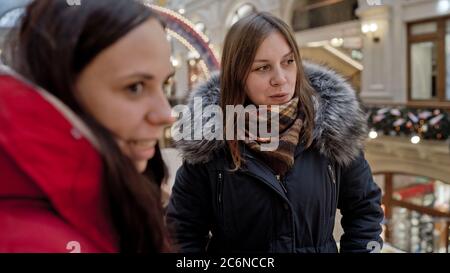 The meeting of the girlfriends. Two women are discussing something in a shopping center. Stock Photo