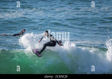 Spectacular action as a male surfer rides a wave at Fistral in Newquay in Cornwall. Stock Photo