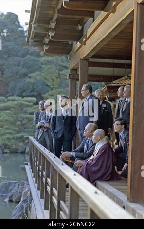 1974, November 21 – Kinkakuji Castle (Gold Pavilion) – Kyoto, Japan – Gerald R. Ford, Zen Buddhist Abbot Jikai Murakami, Interpreter, Secretary of State Henry A. Kissinger,  Donald Rumsfeld; Other Members of US and Japanese Travelling Group – An interpreter sits between President Ford and Zen Buddhist Abbot Jikai Murakami as the two chat in the pavilion above the Cyoko Chi Pond - First Visit to Japan by a Sitting US President - Tour of  Zen Buddhist Shrine - Abbott of Gold Pavilion Stock Photo