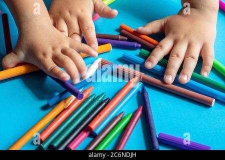 kids holding wax crayons and markers, flat lay Stock Photo