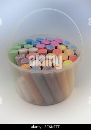 Colorful chalks in plastic bucket isolated on white background. Close-up, layout. Place for text and labels. Set children's large chalk for drawing on Stock Photo