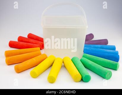 Colorful chalks in plastic bucket isolated on white background. Close-up, layout. Place for text and labels. Set children's large chalk for drawing on Stock Photo