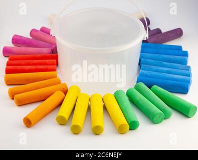 Colorful chalks in plastic bucket isolated on white background. Close-up, layout. Place for text and labels. Set children's large chalk for drawing on Stock Photo