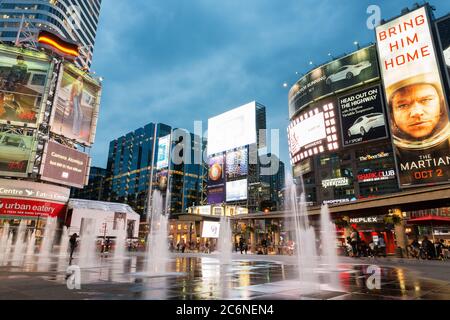 Toronto, Canada - September 12, 2015: People shopping and relaxing at Yonge and Dundas Square in Toronto at dusk, illuminated by the lights of the col Stock Photo