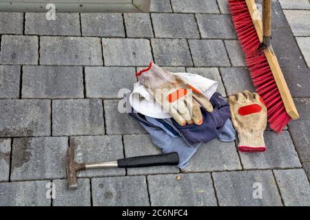 Newly laid concrete pavement slabs. The worker put the hammer, gloves, T-shirts and broom on the same. Stock Photo