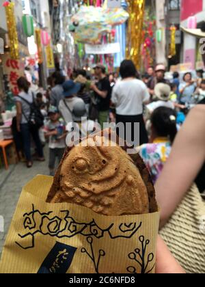 Tokyo, Japan - 5 August 2019: Taiyaki,  a Japanese dessert made from fish-shaped waffles. Japanese street food at summer festival. Stock Photo