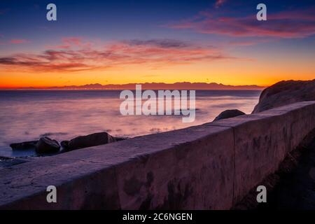 View of a cloudy sunrise from Boulders beach with a view of False Bay, Simon's Town , Cape Town, South Africa Stock Photo