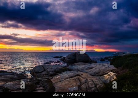 View of a cloudy sunrise from Boulders beach with a view of False Bay, Simon's Town , Cape Town, South Africa Stock Photo