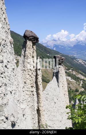 Pyramides d'Euseigne or fairy chimney rock formations in Swiss Alp. Rocks stay in balance on eroded former glacier moraine. A road pass was built unde Stock Photo