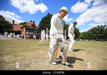 Opening batsman make their way out for the start of a village game at Tilford Cricket Club, Farnham. Stock Photo