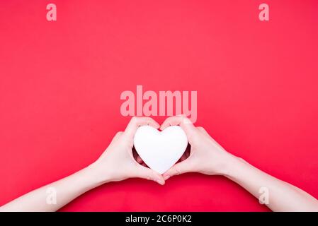 Woman holding decorative heart on red background, top view. Space for text Stock Photo