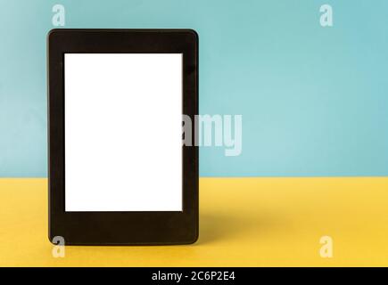 A modern black electronic book with a white blank empty screen on yellow background with empty space Stock Photo