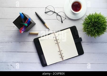 flat composition coffee, notepad and eyeglass on white background . Stock Photo
