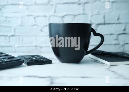 Black mug mockup with with keyboard, notebooks on table  Stock Photo