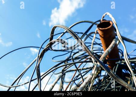 Skein of old wire on a background of blue sky Stock Photo