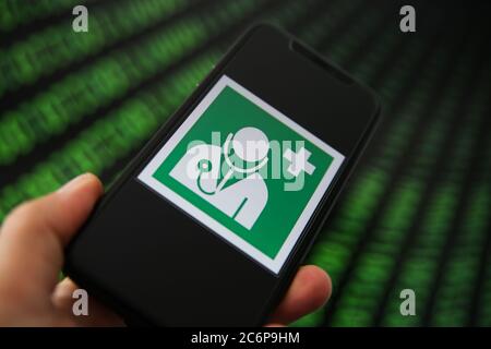 Viersen, Germany - July 9. 2020: Central health data storage management concept: View on mobile phone with international doctor health sign. Blurred b Stock Photo