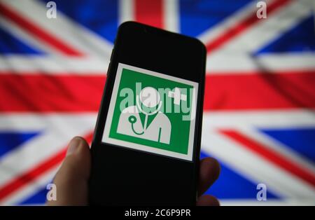 Viersen, Germany - July 9. 2020: View on isolated mobile phone screen with international health and medical doctor symbol. Blurred union jack flag bac Stock Photo