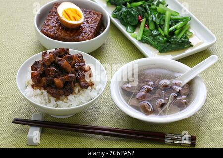 taiwanese home cooking: braised pork rice, chicken gizzard soup, simmered tofu and egg, and stir fried greens Stock Photo