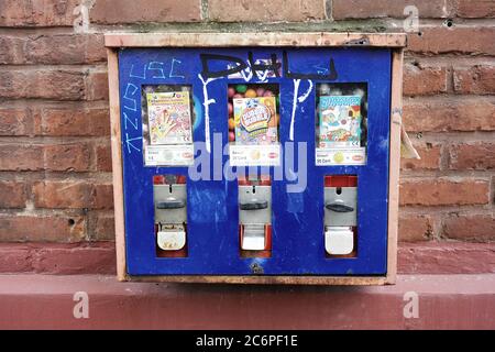 Close-up front view of a retro chewing gum coin vending machine on the wall of a building. Retro filter. Stock Photo