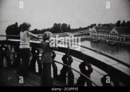 Fine 70s vintage black and white lifestyle photography of young tourists admiring the scenic town. Stock Photo