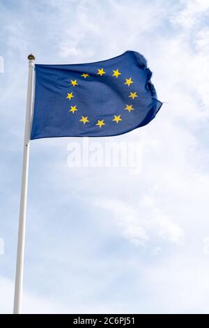 waving flag of European Union in cloudy sky in mat Stock Photo