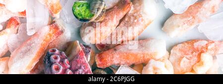 assortment of frozen seafood on ice cubes, shrimps, octopus, Babylonia areolata shellfish snails, langoustines, rich in iodine, antioxidants and vitam Stock Photo