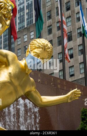 Prometheus in Rockefeller Center features a giant face mask because of the Coronavirus Pandemic, USA Stock Photo