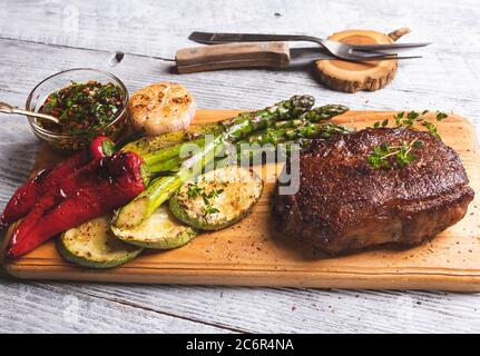 juicy roasted steak with asparagus, pepper, zucchini, sauce  close up Stock Photo