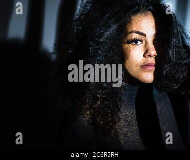 Unusual lighting on beautiful mixed race woman Stock Photo