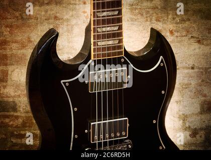 A Gibson SG Standard electric guitar with brick wall. Stock Photo