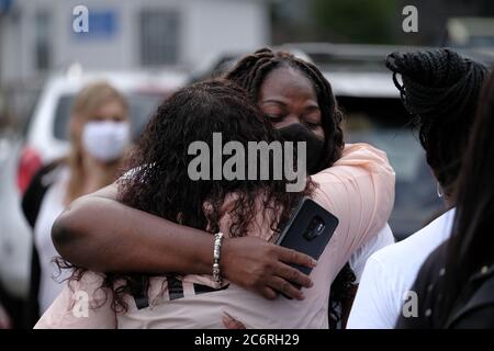 Portland, USA. 11th July, 2020. A woman hugs the mother of Dominique Dunn as family and friends gather outside the Reveal Lounge strip club in Southwest Portland, Ore., on July 11, 2020, to hold a vigil for Dominique who was killed here last Thursday. Police arrested Jordan Clark, 25, for murder in connection with the shooting, but questions remain after family members posted on social media that Dominique was called a racial slur before he was killed. (Photo by Alex Milan Tracy/Sipa USA) Credit: Sipa USA/Alamy Live News Stock Photo