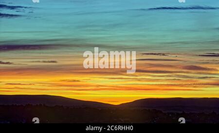 Glasgow, Scotland, UK 12th July, 2020: UK Weather: Candy stripe dawn over the gap in the campsie fell hills to the north of the city. Credit: Gerard Ferry/Alamy Live News Stock Photo