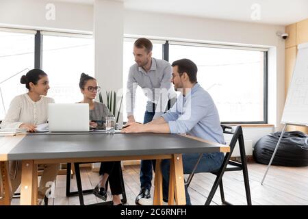 Multiracial colleagues brainstorm work on laptop at meeting Stock Photo