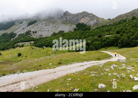 Mother and son walking on gravel road on the plateau at Bukumirsko lake with great mountain view, Montenegro Stock Photo