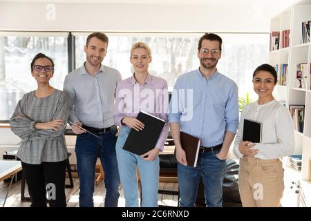 Portrait of smiling multiracial employees posing in office together Stock Photo