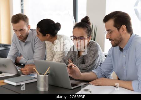 Diverse colleagues work on laptops at office meeting Stock Photo