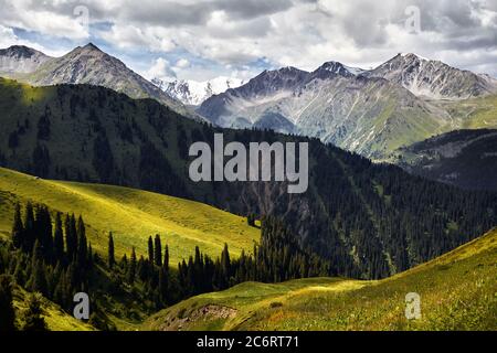 Aerial view of the mountain valley with lush forest and snowy peak in Kazakhstan Stock Photo