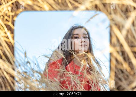 Brunette Red dress girl looking herself reflection  Stock Photo