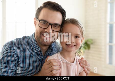 Head shot portrait smiling father wearing glasses and little daughter Stock Photo