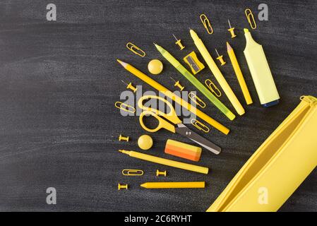 Top above overhead view photo of set yellow stationery and pencil box placed to the right side isolated on blackboard with copyspace empty blank place Stock Photo