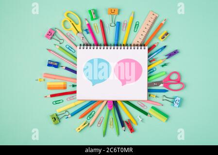 Discussion concept. Top above overhead view photo of colorful stationery and blank notebook with blue and pink bubbles isolated on turquoise backgroun Stock Photo