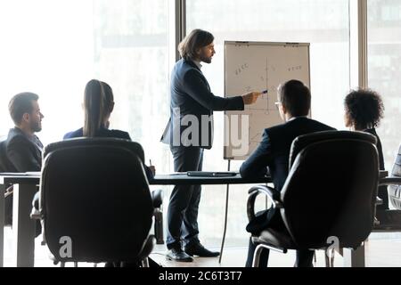 Young male bearded business trainer explaining marketing research results. Stock Photo