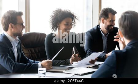 Happy young african american leader enjoying relaxed atmosphere with colleagues. Stock Photo