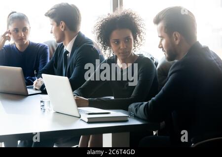 Young diverse business people, working in small groups on projects. Stock Photo