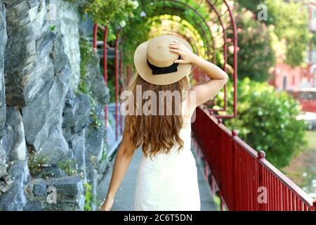 Rear view of tourist girl runs the Walk of Lovers in Varenna on Lake Como, Italy