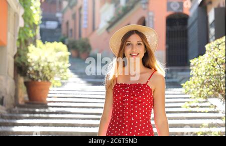 Happy travel tourist woman going downstairs in Bellagio on Lake Como, Italy. Girl on summer vacation visiting famous tourist destination in Europe. Stock Photo