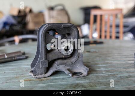 Old rubber engine mount with tools on the table background. Stock Photo