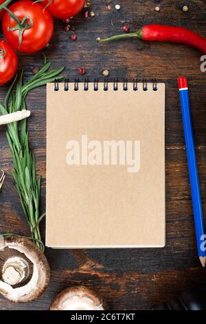 vegetables and a paper notebook on a spiral, on a brown wooden ...