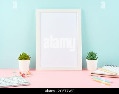 Mockup with blank white frame, alarm, notepad, keyboard on pink table Stock Photo