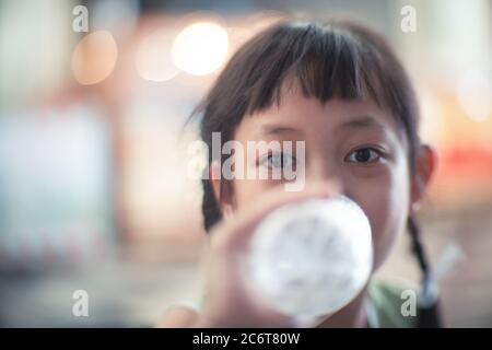 Asian child girl drinking a bottle of water with smile and happy Stock Photo